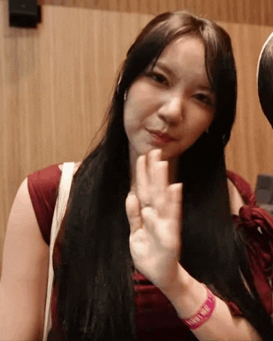 a woman with long black hair is wearing a wristband that says ' i 'm sorry ' on it .