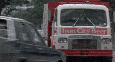 a red and white iron city beer truck with the number 67
