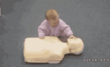 a baby is crawling on top of a mannequin on the floor .