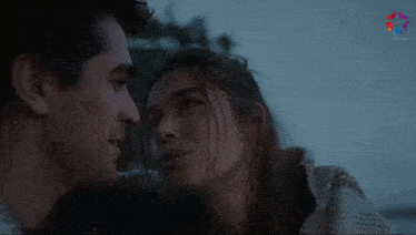 a man and a woman are looking into each other 's eyes with a purple star in the background