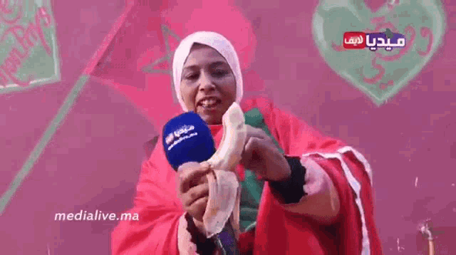 a woman is holding a microphone in front of a wall that says medialive.ma on it