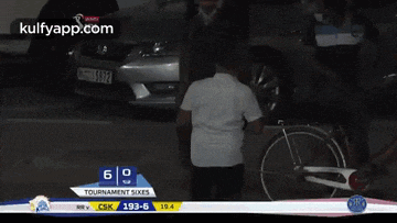 a man in a white shirt is standing in front of a car with a license plate that says 2925 on it