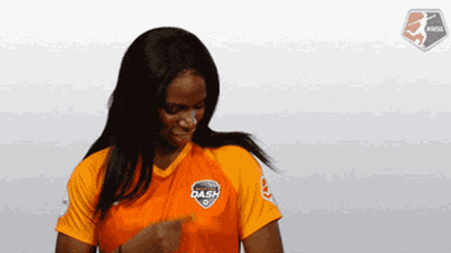 a woman wearing a dash jersey is pointing at something