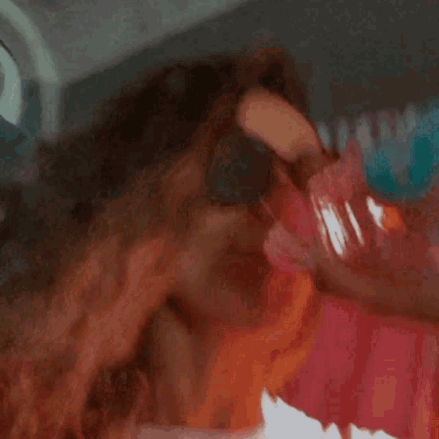 a woman drinking from a bottle with a blue cap
