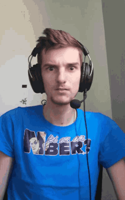 a man wearing headphones and a blue shirt that says biber on it