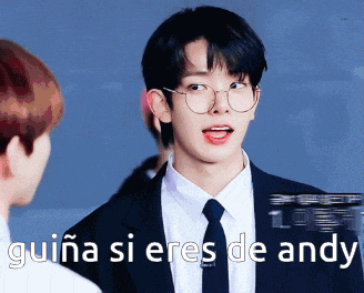 a man in a suit and tie is talking to another man with guina si eres de andy written below him
