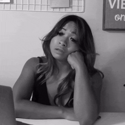 a black and white photo of a woman sitting at a desk