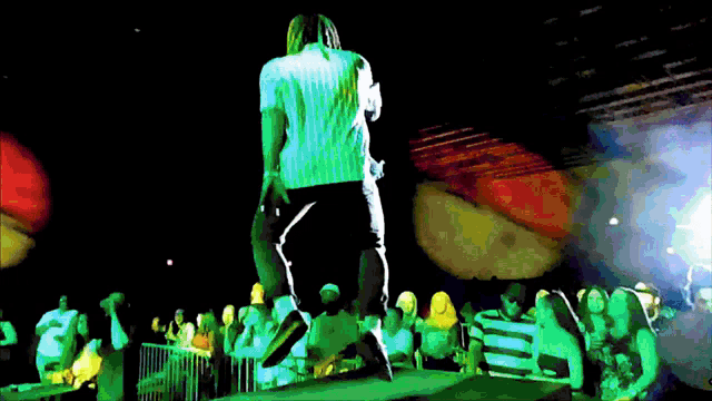 a man is standing on a stage with a microphone in his hand