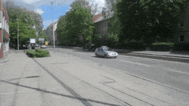 a police car is driving down a street with trees in the background