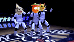 a group of stormtroopers are dancing on a basketball court with the new orleans pelicans logo in the background