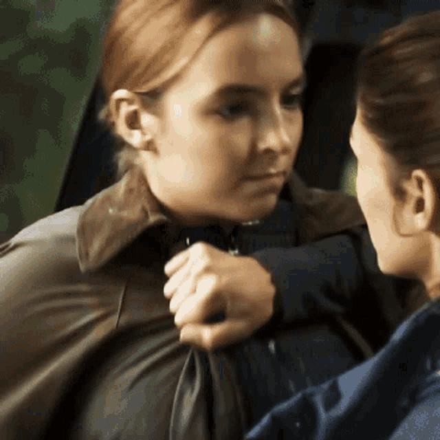 a woman is holding another woman 's arm and talking to her .