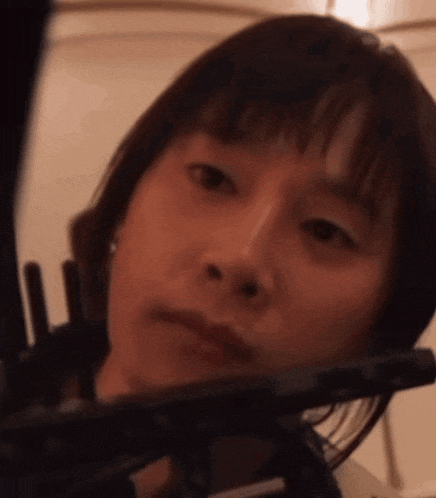 a close up of a woman 's face with a fork in her hand