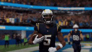 a football player with the number 5 on his jersey runs with the ball