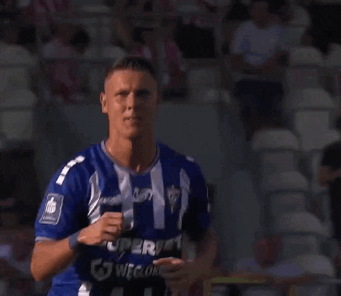 a man in a blue and white striped shirt with superbet on the front