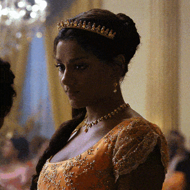 a woman wearing a tiara and a necklace looks at the camera