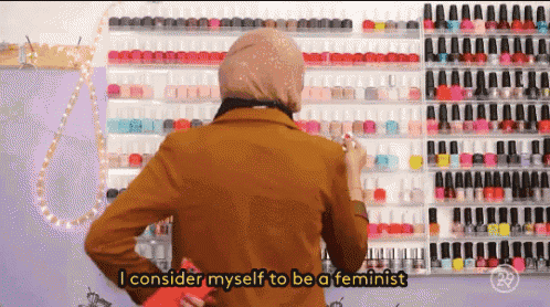 a woman standing in front of a wall of nail polish says i consider myself to be a feminist ..