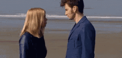 a man and a woman are looking at each other and touching their faces .
