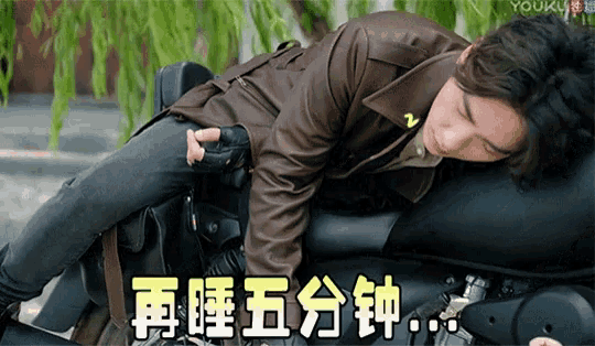 a man in a brown jacket is laying on a black motorcycle with chinese writing on it