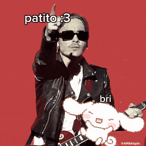 a man in a leather jacket is holding a guitar and pointing up with the words patito : 3 below him