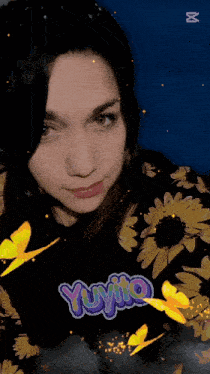 a woman wearing a black shirt that says yuyito is surrounded by butterflies