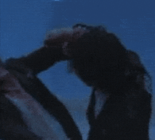 a blurry picture of two people standing next to each other in a dark room