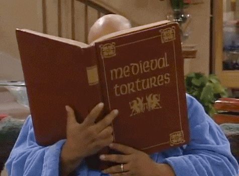 a man in a blue robe is reading a book titled medieval tortures