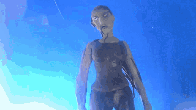 a statue of a woman is standing in front of a blue sky