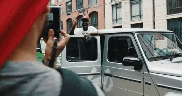 a man is taking a picture of a man in a car