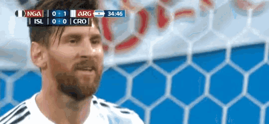 a man with a beard is standing in front of a soccer goal during a game .