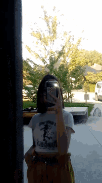 a woman taking a picture of herself with a phone and a shirt that says ' remember ' on it