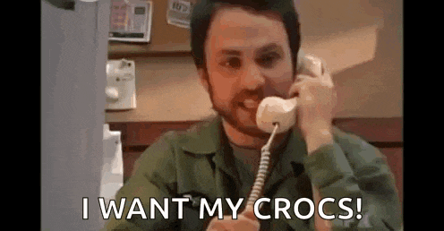 a man is talking on a phone and saying `` i want my crocs '' .