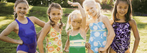 a group of young girls are posing for a picture in their swimsuits
