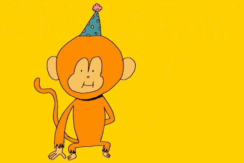 a monkey wearing a birthday hat is holding flowers