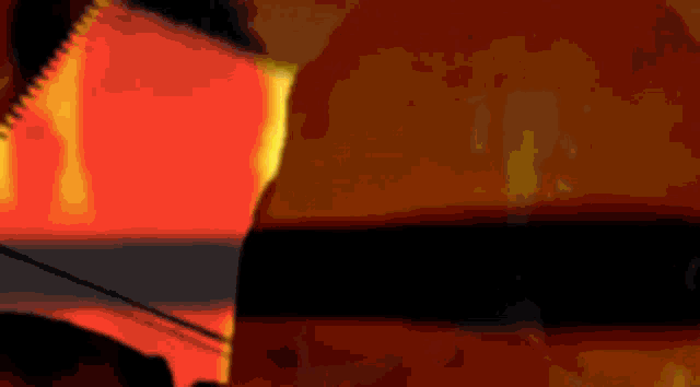 a person is standing in front of a fire with a saw .