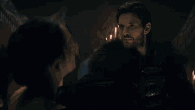 a man and a woman are looking at each other in the dark