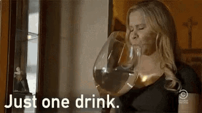 a woman is drinking a large glass of wine and says `` just one drink '' .