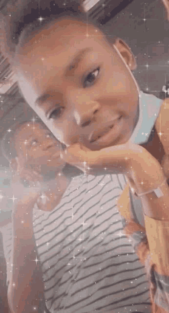 a little girl wearing a mask is taking a selfie with a person .
