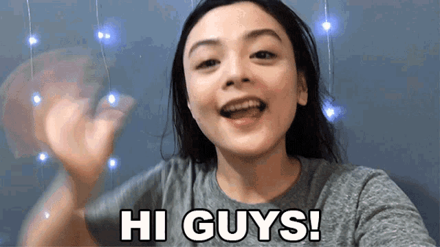 a woman says hi guys and waves at the camera