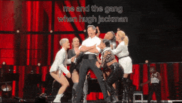 a group of people on a stage with the words me and the gang when hugh jackman above them