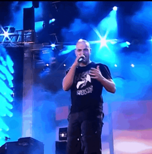 a man singing into a microphone wearing a shirt that says ' special ' on it