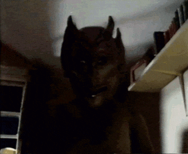 a dark room with a shadow of a person with horns