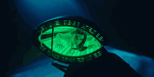 a woman 's face is visible through a green light