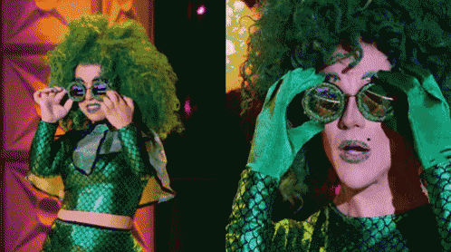 a woman with green hair is wearing sunglasses and a green top