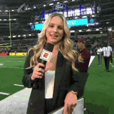 a woman is holding a microphone with the letter m on it