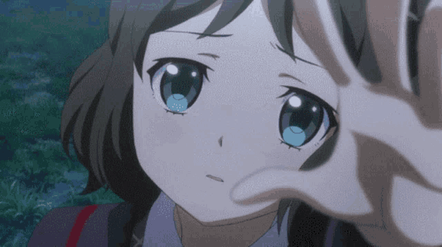 a close up of a girl 's face with a hand covering her face
