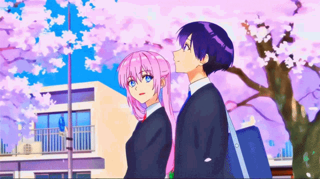 a boy and a girl are standing next to each other in front of a cherry blossom tree
