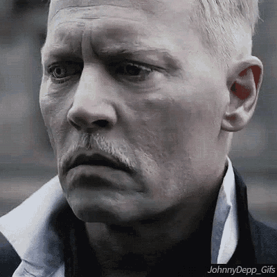 a close up of a man 's face with a mustache and a white shirt .