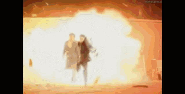 a man and a woman are running away from an explosion .