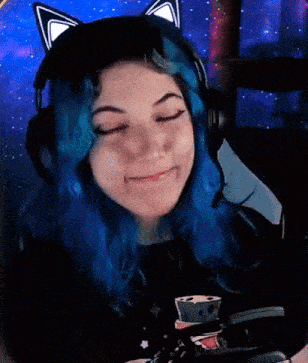 a girl with blue hair is wearing headphones and giving a thumbs up