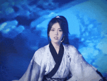 a woman in a kimono is standing in front of a blue sky
